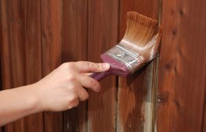 Процесс покраски деревянного ограждения